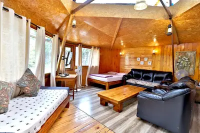a living room with a couch and a table at De Rock Jungle Living Resort in Coonoor