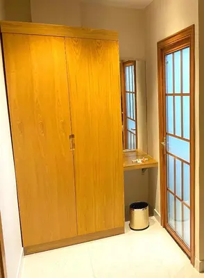 a large wooden cabinet in a room with a window at TAG HOTELS in Irugūr
