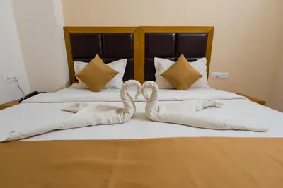 two towels in the shape of a heart on a bed at TAG HOTELS in Irugūr