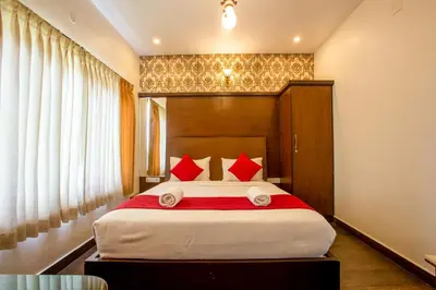 a bedroom with a large bed with red pillows at The Baron in Ooty
