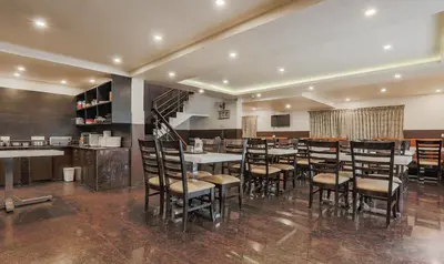 a restaurant with tables and chairs in a room at The Baron in Ooty