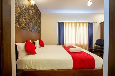 a bedroom with a large bed with red pillows at The Baron in Ooty