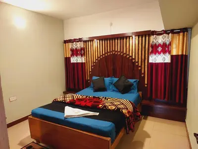 a bedroom with a bed with a wooden headboard and curtains at IMPERIAL COTTAGE, HILL BUNK OOTY in Ooty