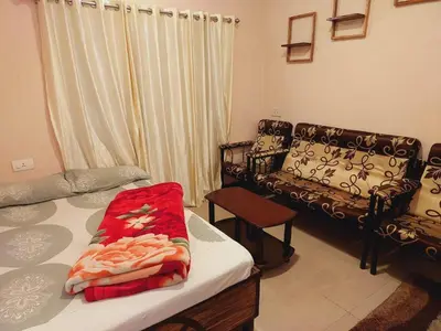 a living room with a bed and a couch at IMPERIAL COTTAGE, HILL BUNK OOTY in Ooty