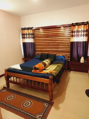 a bedroom with a bed with a wooden headboard at IMPERIAL COTTAGE, HILL BUNK OOTY in Ooty