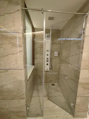 a shower with a glass door in a bathroom at Fezinn Hotel - Best Wayanad Hotel in 2024 in Kozhikode