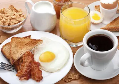 a breakfast plate with eggs and bacon and a cup of coffee at The Arcadia Coimbatore Airport in Coimbatore