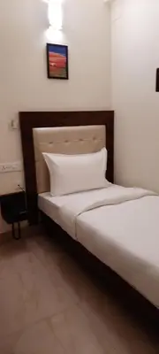 a bedroom with two twin beds with a headboard and aermott at ADVAITHA RESIDENCY in Mysore