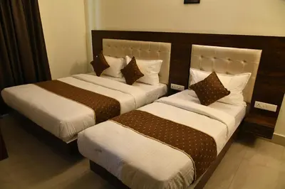 two beds sitting next to each other in a room at ADVAITHA RESIDENCY in Mysore