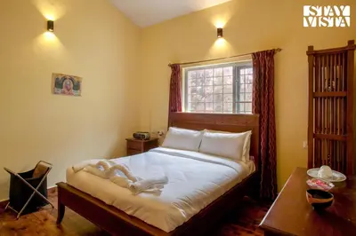a bedroom with a large bed and a window at StayVista at Zolas Retreat 2BHK Pet Friendly and Breakfast Included in Coonoor