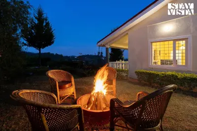 a group of chairs around a fire pit in a yard at StayVista at Zolas Retreat 2BHK Pet Friendly and Breakfast Included in Coonoor