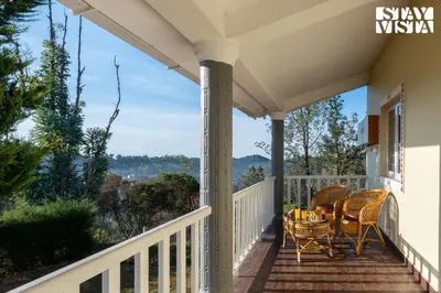 a porch with a table and chairs on it at StayVista at Zolas Retreat 2BHK Pet Friendly and Breakfast Included in Coonoor