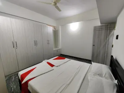 a bedroom with a bed with a red and white blanket at Vogel's Nest in Mysore