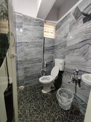 a bathroom with a toilet and a sink at Vogel's Nest in Mysore