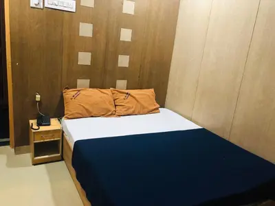 a bedroom with a blue and white bed and a nightstand at C M HOTEL NEW in Wodapatti