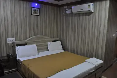 a hotel room with a bed and a air conditioner at C M HOTEL NEW in Wodapatti