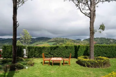 a table and two chairs sitting in a yard at StayVista at Casa Pinnacle - Pet Friendly Home with Lawn in Coonoor