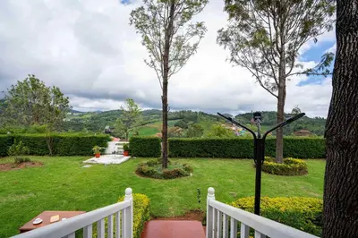 a view of a yard with a white fence at StayVista at Casa Pinnacle - Pet Friendly Home with Lawn in Coonoor