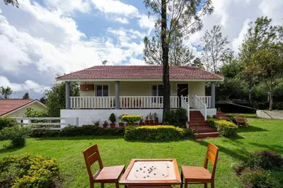 a house with a table and chairs in the yard at StayVista at Casa Pinnacle - Pet Friendly Home with Lawn in Coonoor