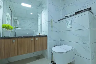a white bathroom with a sink and a toilet at Krishnavalsam Regency in Guruvāyūr