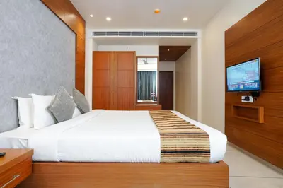 a bedroom with a large bed and a flat screen tv at Nexstay River Mouth International in Ferokh