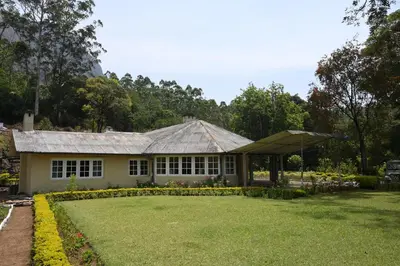 a house with a large lawn in front of it at Ama Stays and Trails Tea Estate Bungalows , Munnar in Munnar