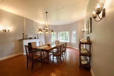 a dining room with a wooden table and chairs at Ama Stays and Trails Tea Estate Bungalows , Munnar in Munnar