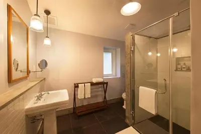 a bathroom with a shower and a sink and a toilet at Ama Stays and Trails Tea Estate Bungalows , Munnar in Munnar