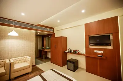 a living room with a couch and a tv at Nesma Palace in Kannur