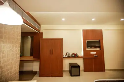 a room with wooden cabinets and a television at Nesma Palace in Kannur