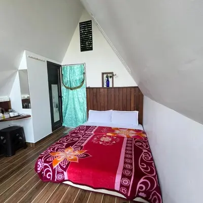 a bedroom with a bed with a red blanket at Casita Greens in Kondotti