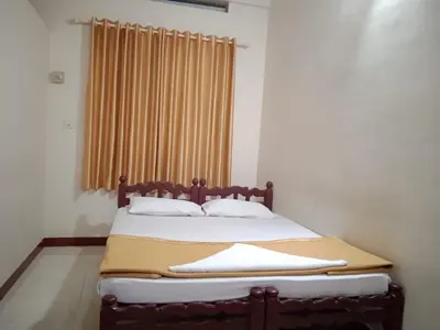 a bed sitting in a room with a window at Jinan city centre in Alwaye