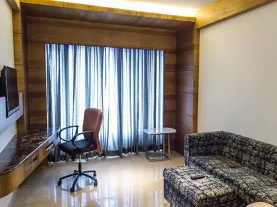 a living room with a couch and a chair at Diana Heights Luxury Hotel in Nedumbassery