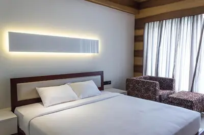 a hotel room with a bed and a chair at Diana Heights Luxury Hotel in Nedumbassery
