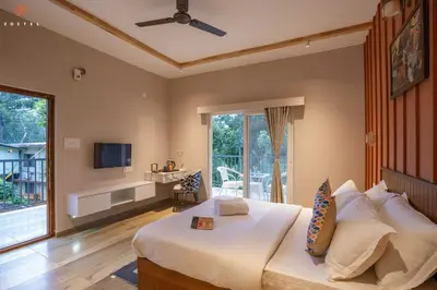 a bedroom with a large bed and a television at Zostel Coorg, Madikeri in Madikeri