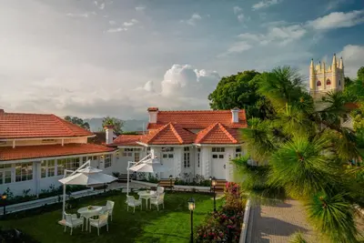 a group of white buildings with tables and chairs at Gateway Coonoor in Coonoor