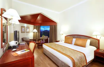 a hotel room with a large bed and a desk at The Gateway Hotel Beach Road, Calicut in Kozhikode