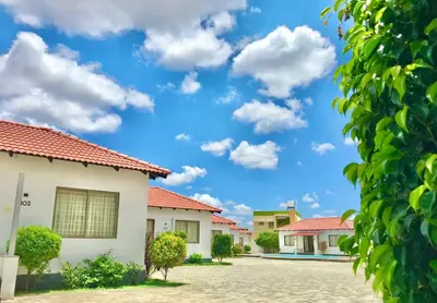 a row of houses with a blue sky and clouds at MALLI resort in Dhārāpuram