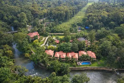 an aerial view of a house next to a river at Regenta Jungle Resort Kabini Springs in Begūr