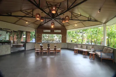 a dining room with chairs and tables and windows at Regenta Jungle Resort Kabini Springs in Begūr