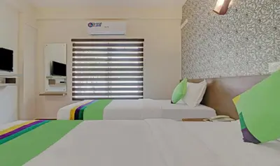 a bedroom with two beds and a window at Treebo Golden Terminal Kochi Airport With Swimming Pool in Cochin
