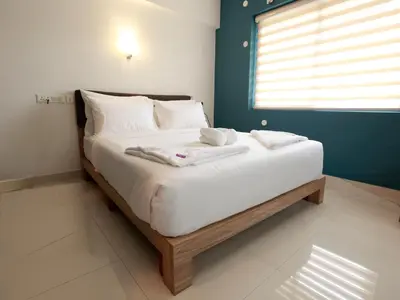 a bed in a room with two towels on it at Transit Suites by GrandWest in Nedumbassery