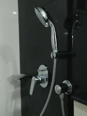 a shower in a bathroom with a faucet at Transit Suites by GrandWest in Nedumbassery