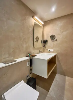 a bathroom with a white sink and a toilet at Lago Leisure Resort & Spa in Cherai Beach