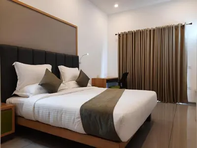 a bedroom with a large bed with a black headboard at Lago Leisure Resort & Spa in Cherai Beach