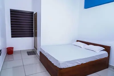 a bed in a white room with a window at THEKKUMPURAM RESIDENCY in Kondotti