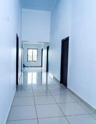 an empty hallway with white walls and black doors at THEKKUMPURAM RESIDENCY in Kondotti