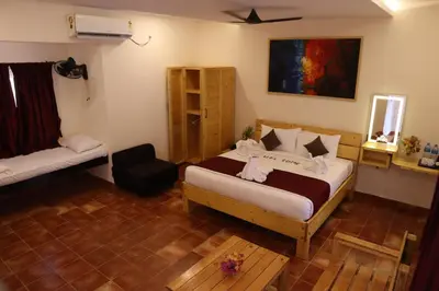 a bedroom with a bed and a chair in it at Royal Destiny Resort in Malaiyāndipattanam
