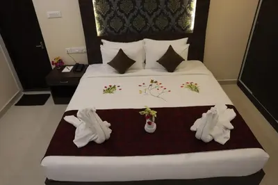 a hotel room with a bed with white shoes on it at Royal Destiny Resort in Malaiyāndipattanam