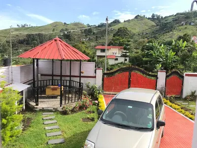 a white car parked in front of a gazebo at Kodai Countryside Homestay in Kodaikānāl